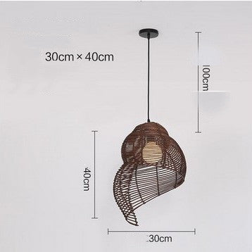 Lámpara colgante Caracol de mimbre, encendida creando luz cálida