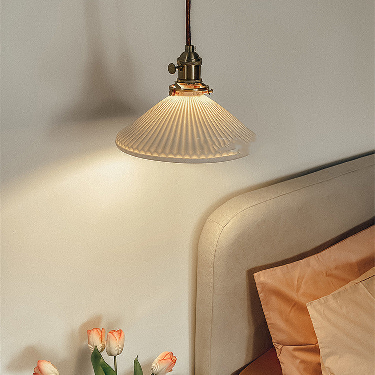 Lámpara colgante Kumo de latón y porcelana, encendida creando luz cálida